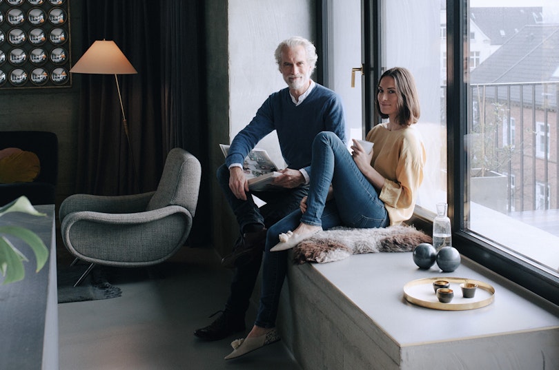 Middle-aged couple sitting on a windowsill in a new flat.